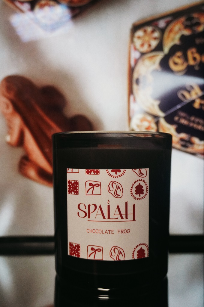 Red candle 'Apple Pie' with a slice of apple pie resting on top of the container