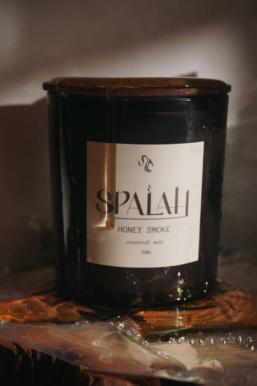 Dark candle 'Honey Smoke' with honey visibly dripping down the jar