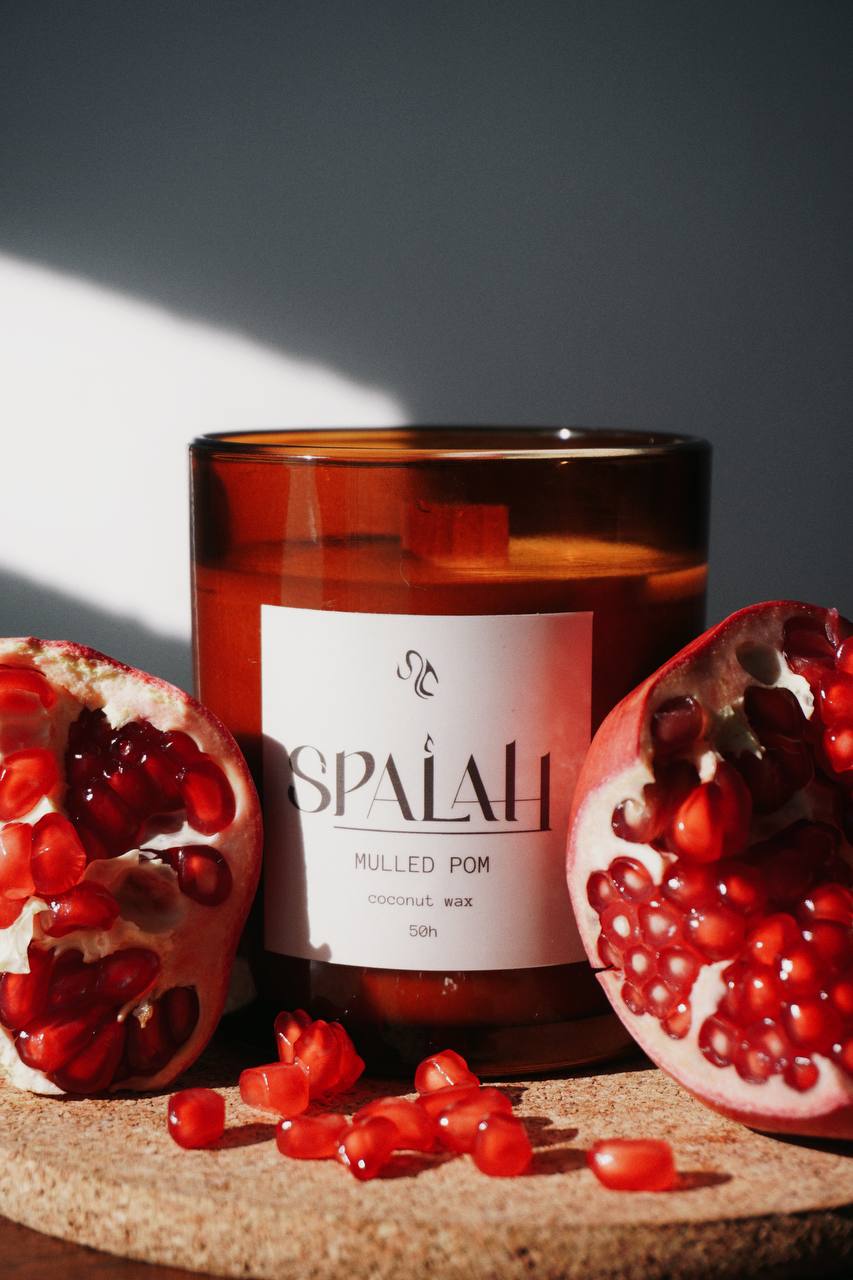 Mulled Pom candle next to sliced pomegranates