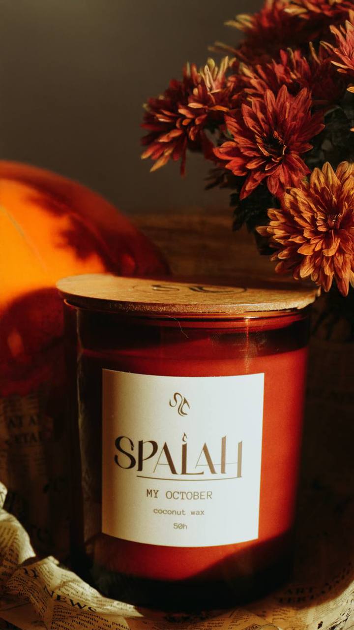 Red candle 'My October' next to dark red chrysanthemums